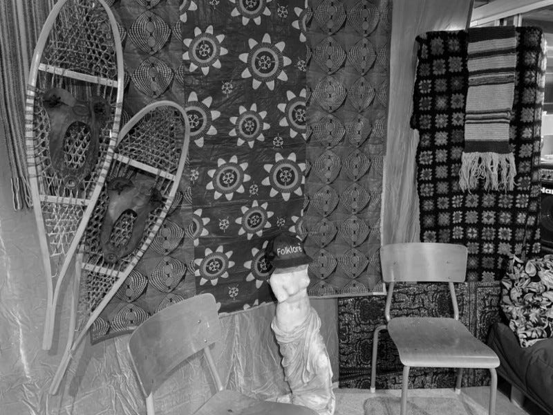 Set for an online concert featuring snowshoes, brightly colored cloth backdrop, statue of Venus de Milo, chair, winter scarf.