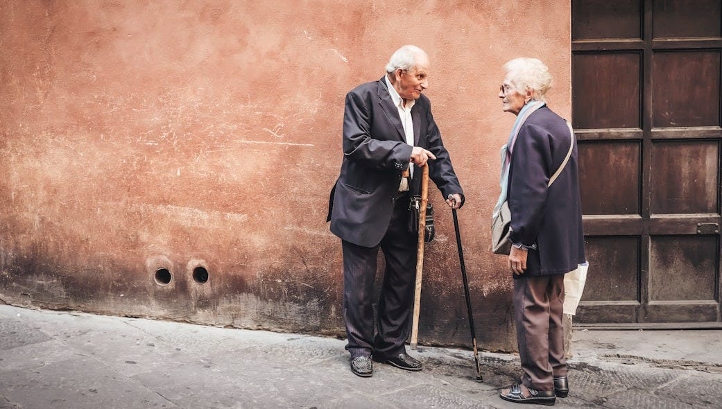 two person talking while standing near wall