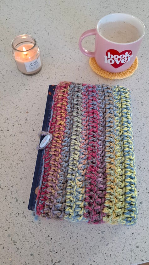 yellow bookmark, pile of crocheted items, rainbow book cozy, yellow pocket, blue coaster, set of pockets