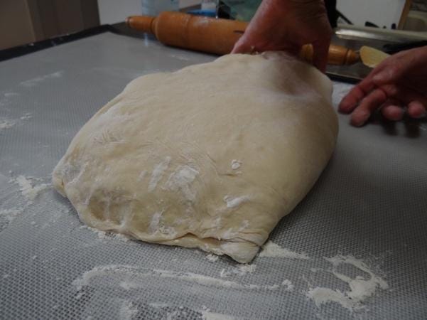 A person holding a dough

Description automatically generated