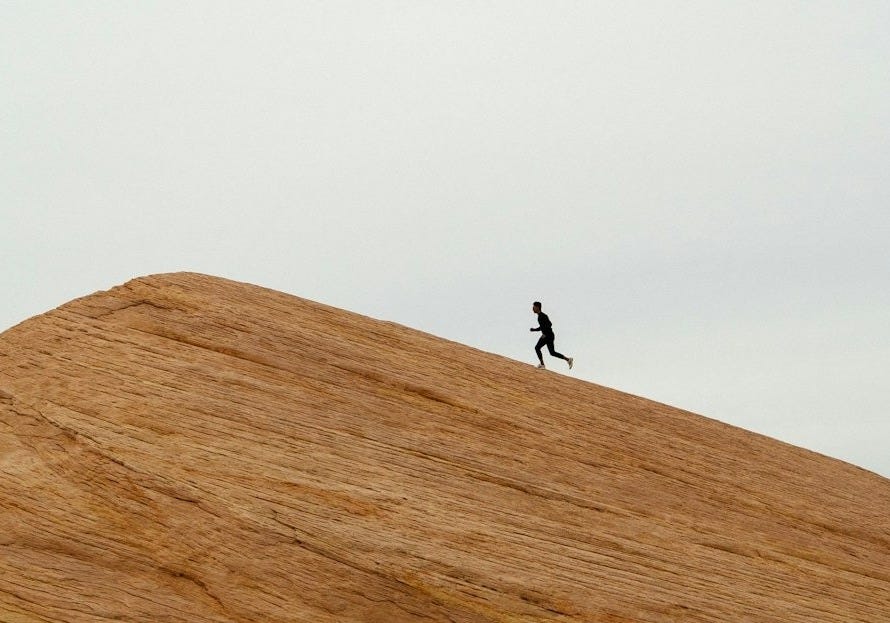 person running on top on hill during daytime