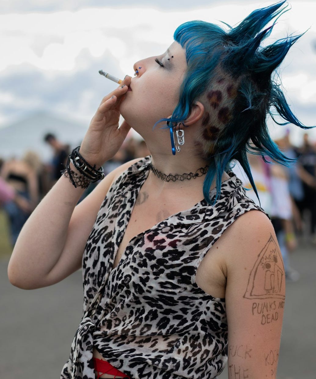 Woman with blue mohawk smoking cigarette