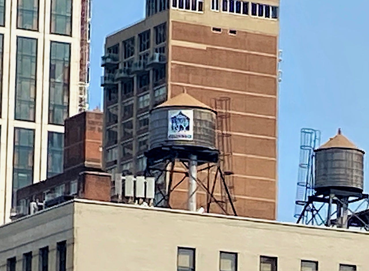 A Rosenwach tank with the archetypal tan top. On the face of the planks is the Rosenwach logo: We Tank NY in the silhouette of a tank and ROSENWACH written beneath.