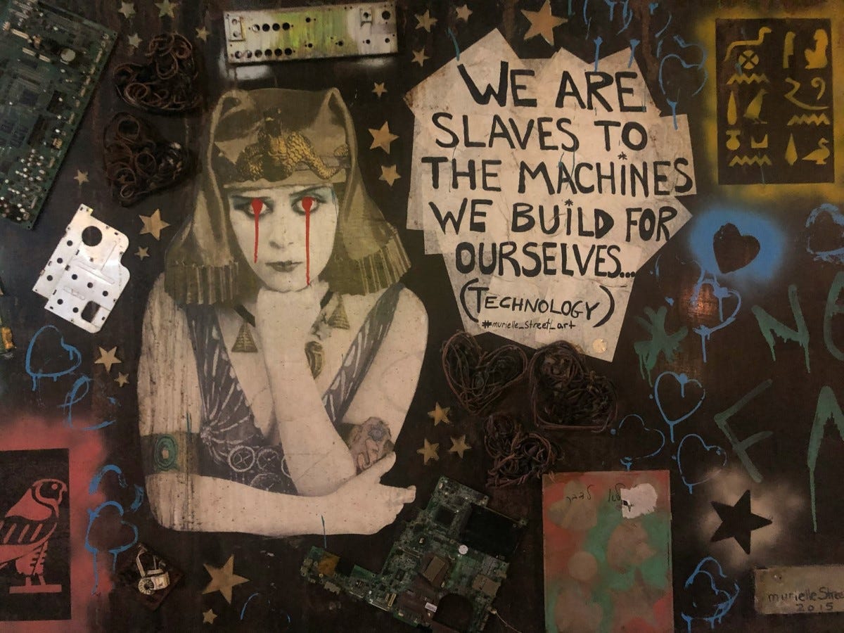 street art montage with message: we are slaves to the machines that we build for ourselves street art montage with message: we are slaves to the machines that we build for ourselves