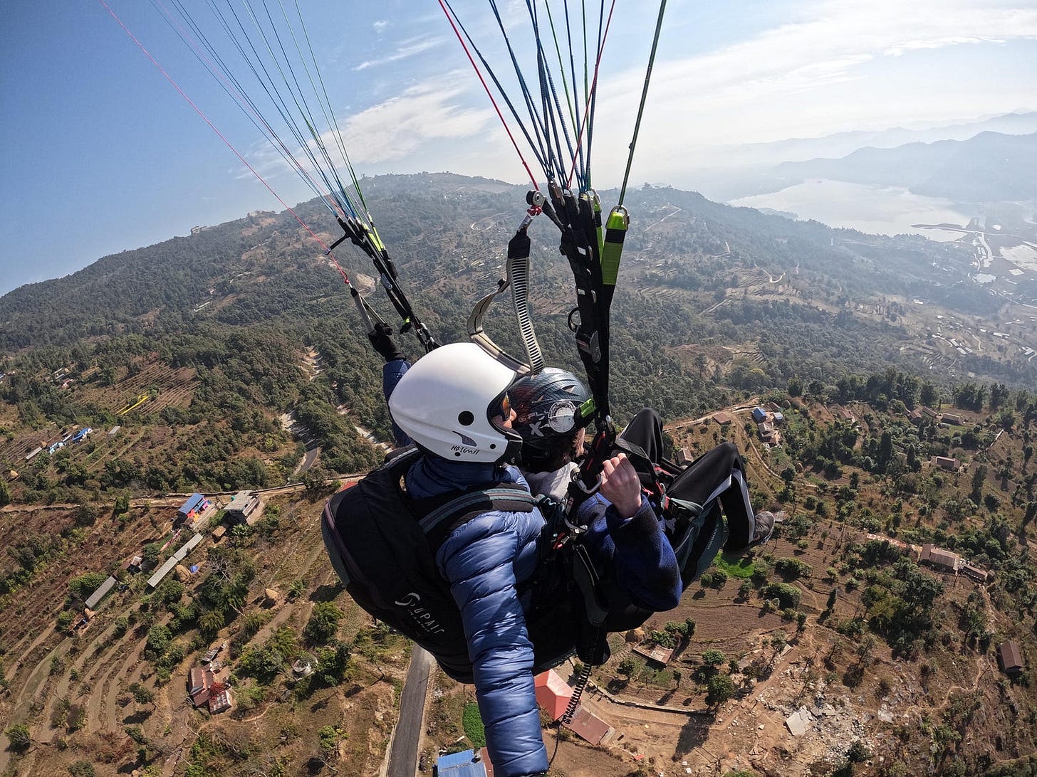 Photo taken from a selfie stick during a parasailing flight from the hills north of Pokhara, Nepal. This photo was taken from about 2000 feet above ground on a sunny, lightly cloudly day in January.