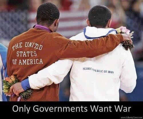Two athletes standing with arms around each other, wearing jackets labeled "The United States of America" and "Islamic Republic of Iran." Each holds a bouquet of flowers. A watermark from liberty.com is visible at the bottom.