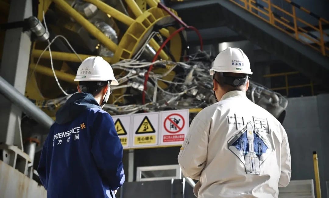 Two Orienspace engineers inspect a Yuanli-110 engine on the test stand in November 2025.