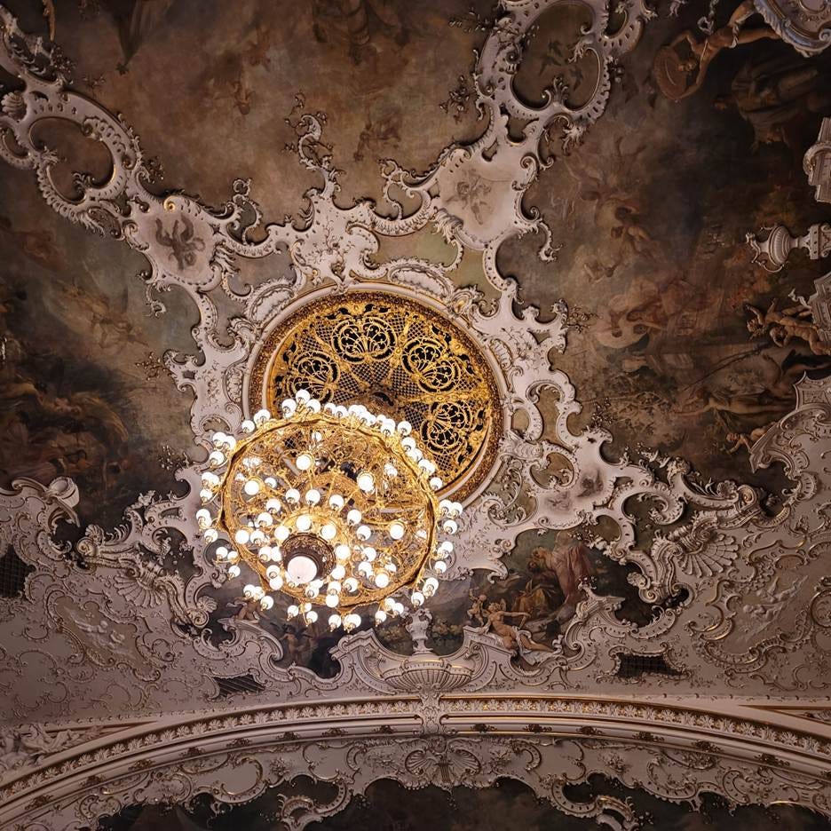 A ceiling with a chandelier and painting

AI-generated content may be incorrect.