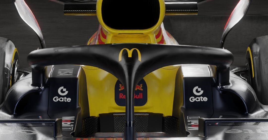Close-up view of front section of Red Bull Racing Formula 1 car with yellow McDonalds golden arches logo integrated into black halo structure above cockpit flanked by red bull logo on sides and Gatorade branding on wing elements and tires visible in dark background