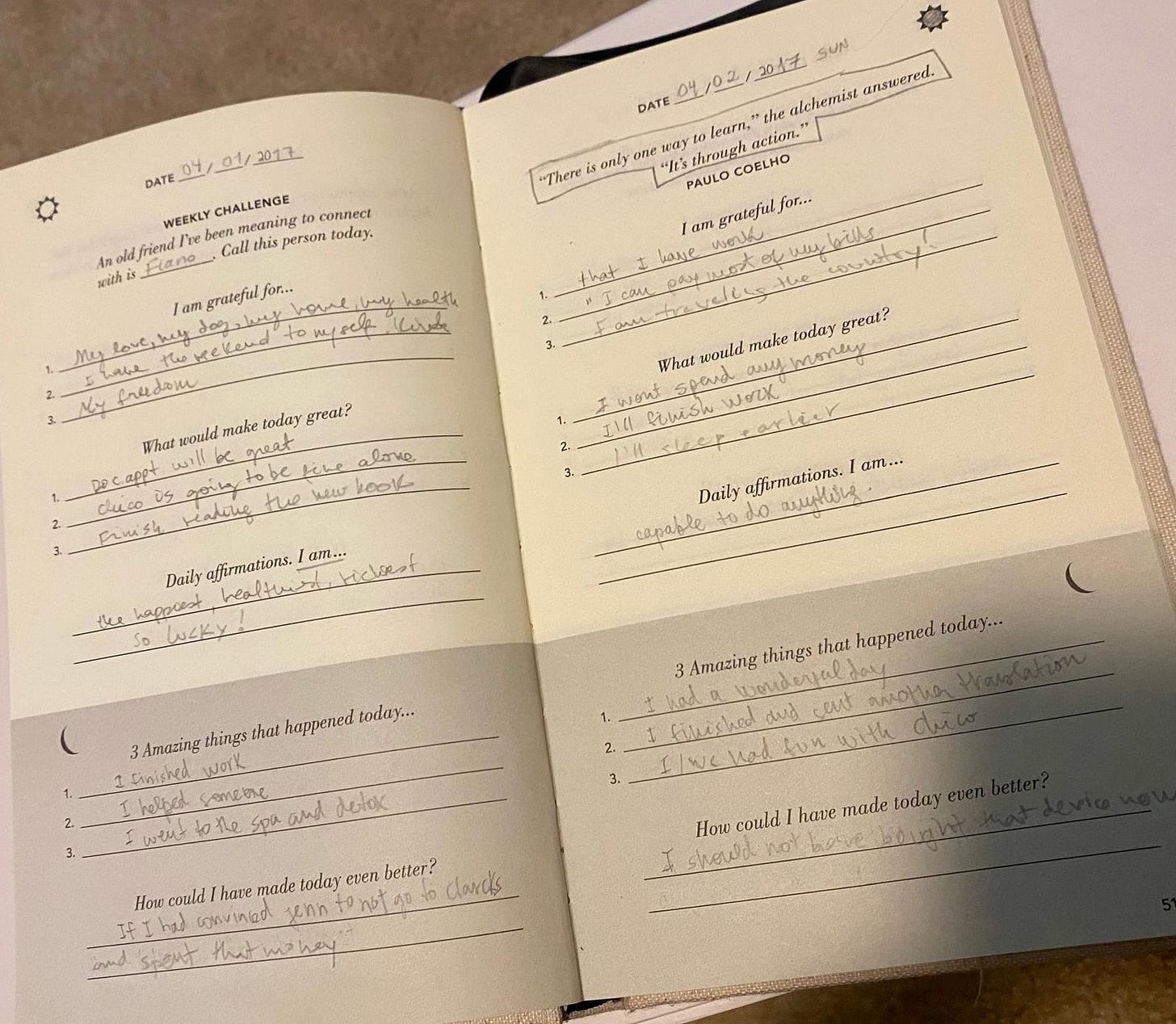 Páginas abertas do '5 Minute Journal' mostrando entradas manuscritas de dois dias do mês de janeiro de 2017, com seções para gratidão, afirmações e reflexões diárias.