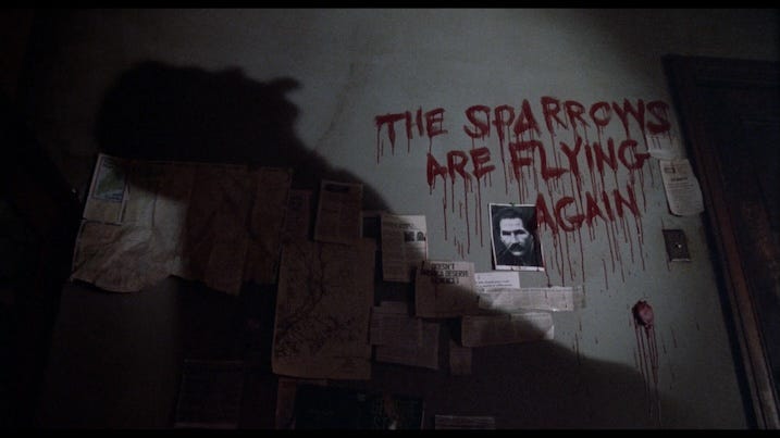 A shadowy figure looms over a blood-smeared message on a wall that reads, “THE SPARROWS ARE FLYING AGAIN.” Pinned articles and a photo of George Stark are visible beneath the writing.