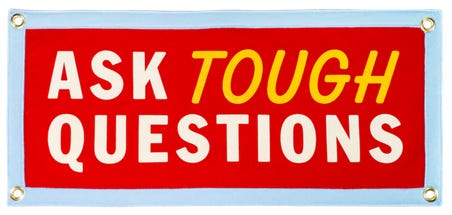 Sign that reads "ask tough questions". Sign that reads "ask tough questions".