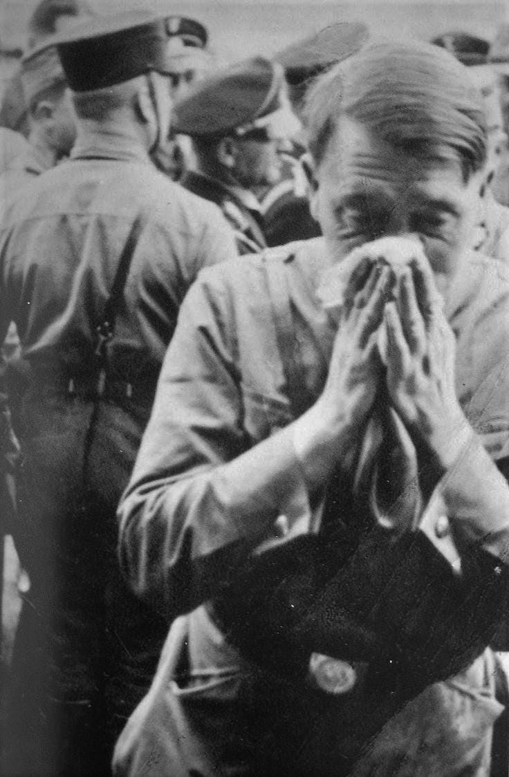 Adolf Hitler blowing his nose backstage at a Nazi rally, 1935.