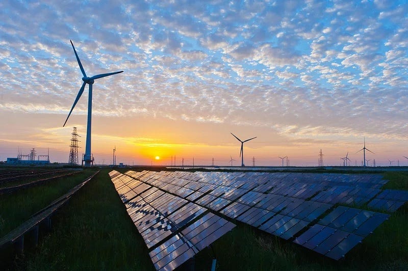 Landscape photo of solar panels and wind farm at sunrise (or maybe sunset) under scattered clouds Landscape photo of solar panels and wind farm at sunrise (or maybe sunset) under scattered clouds