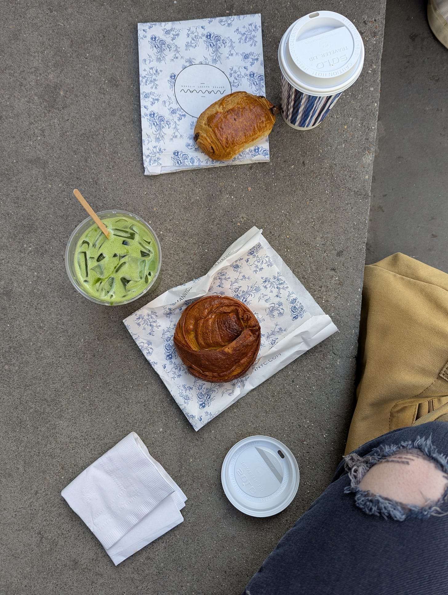 top down photo of two pastries, an iced matcha, and a coffee on a stoop