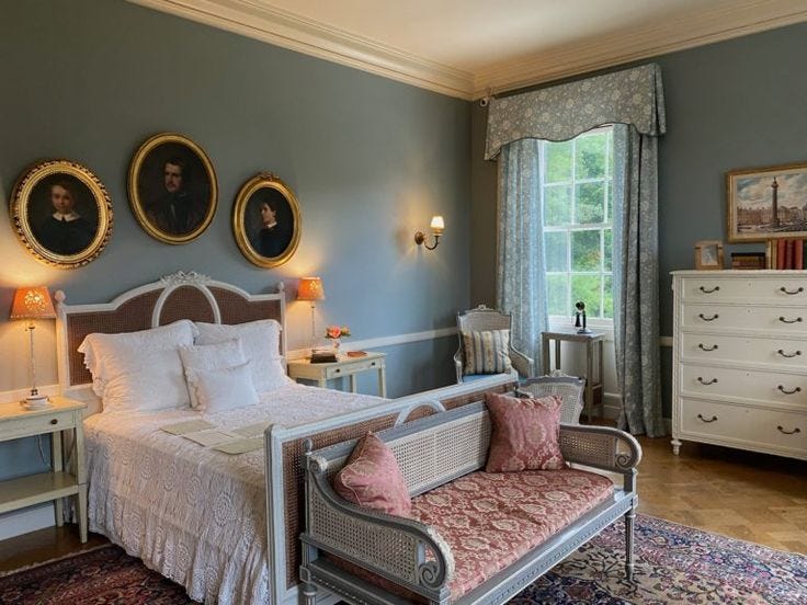 This may contain: a bed sitting in a bedroom next to a window with two pictures on the wall