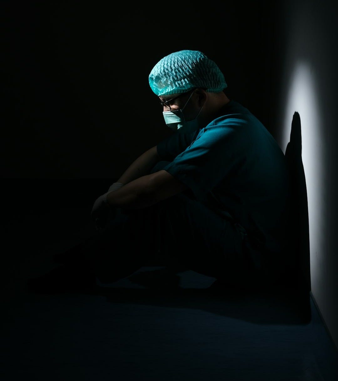 man in green shirt and blue knit cap sitting on floor man in green shirt and blue knit cap sitting on floor