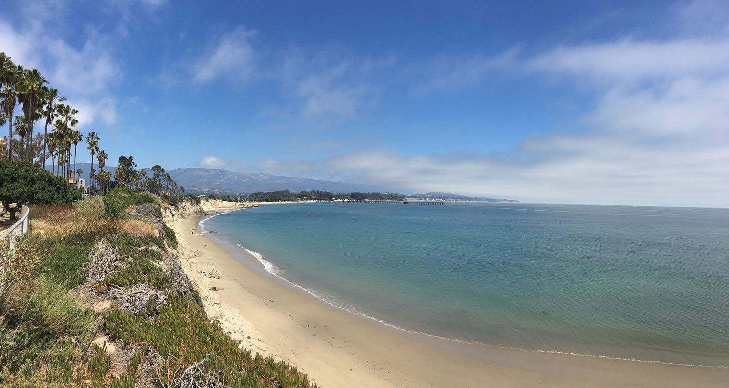 View of the Pacific Ocean, with palm trees and the mountains in the foreground. Clouds are interspersed throughout the sky. View of the Pacific Ocean, with palm trees and the mountains in the foreground. Clouds are interspersed throughout the sky.