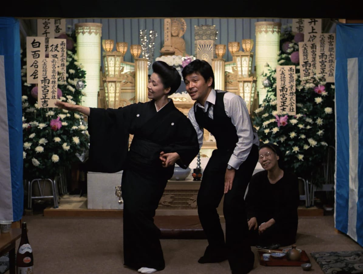The Funeral | Still features a Japanese funeral in the works, with two oddly jovial people in the room.