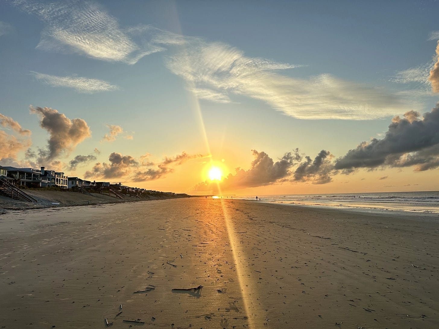 Sunrise over the beach at Isle of Palms, South Carolina, with beach houses along the shore.