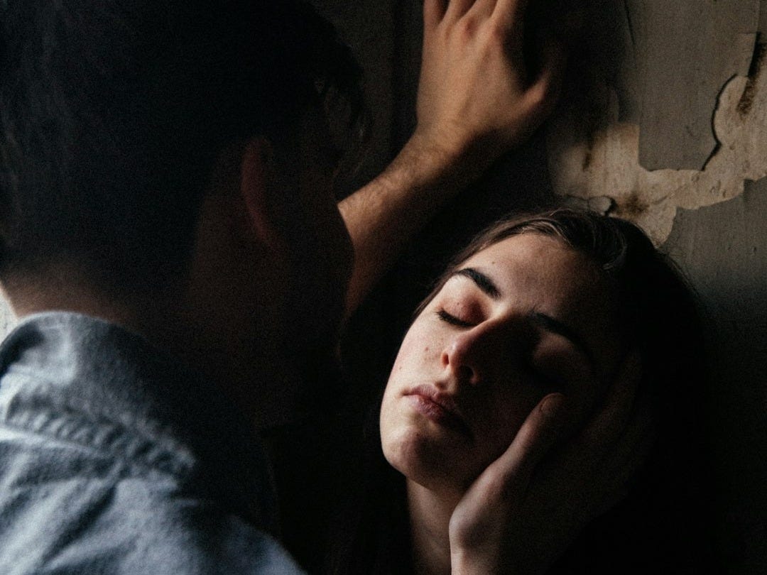 man in blue shirt kissing womans cheek