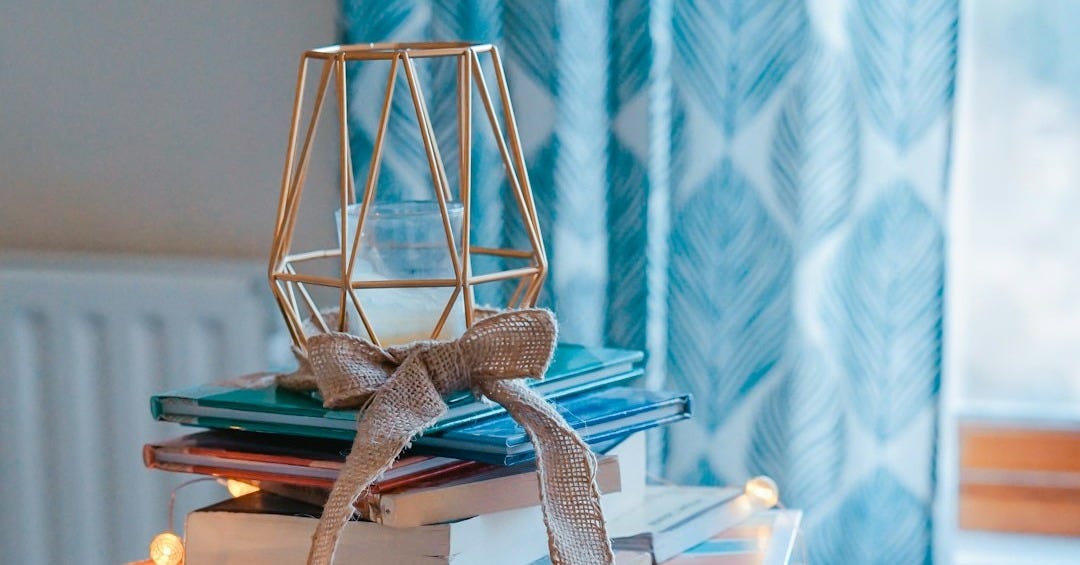 brown wooden framed candle holder on top of books brown wooden framed candle holder on top of books