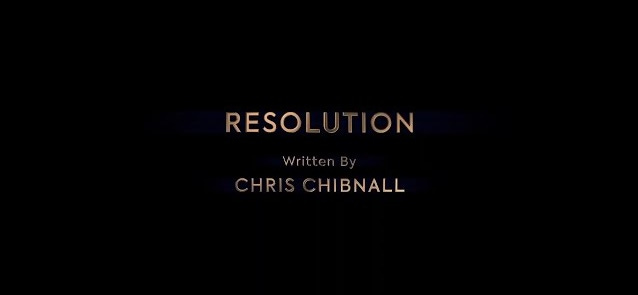 This image shows the title card of "Resolution" (Doctor Who's 2019 New Year's Day Special). Chris Chibnall's writing credit appears below the episode's title. All words are printed in a reddish-golden font. This image shows the title card of "Resolution" (Doctor Who's 2019 New Year's Day Special). Chris Chibnall's writing credit appears below the episode's title. All words are printed in a reddish-golden font.