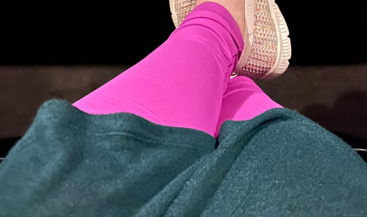 Photo 1: Image of Wicked display at movie theatre; Photo 2: Image of a woman's leg's clad in pink leggings covered by a green dress
