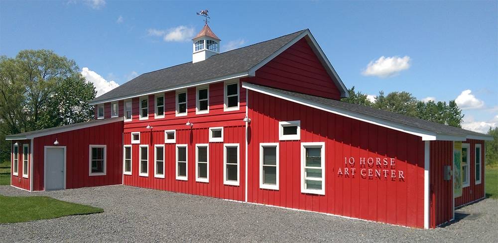 A large red barn with the words 10 Horse Art Center on the side