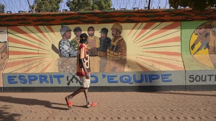 A man walks past a mural in Ouagadougou, Burkina Faso, on March 1, 2023.