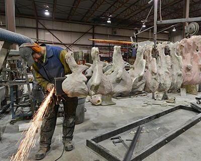 A worker welding the bones and the metal frame of the titanosaur fossil mount. A worker welding the bones and the metal frame of the titanosaur fossil mount.