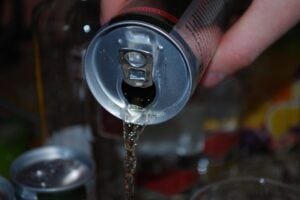 someone pouring a can of energy drink
