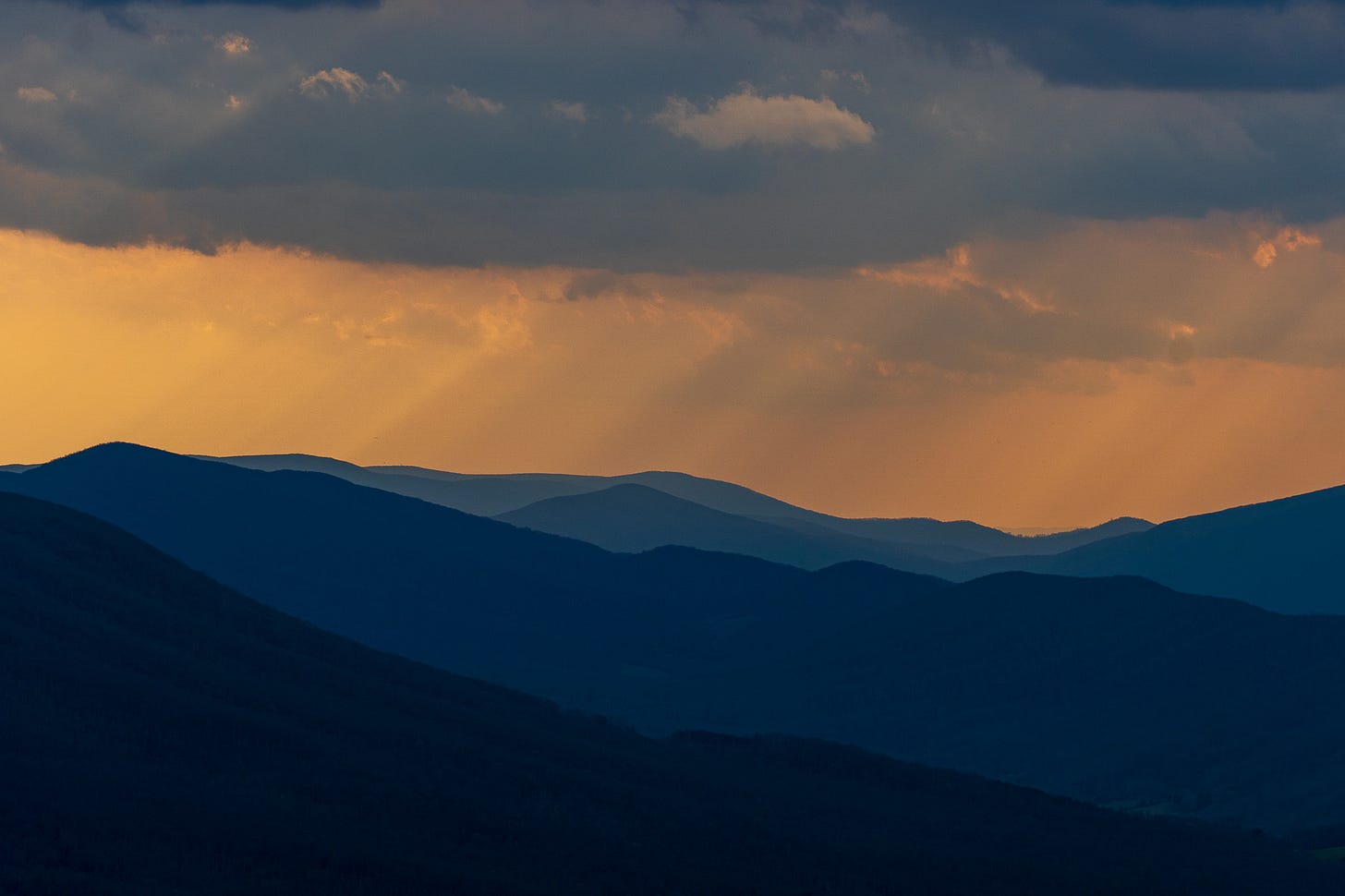 Blue ridge mountains at sunset with intense orange skies and blue mountains