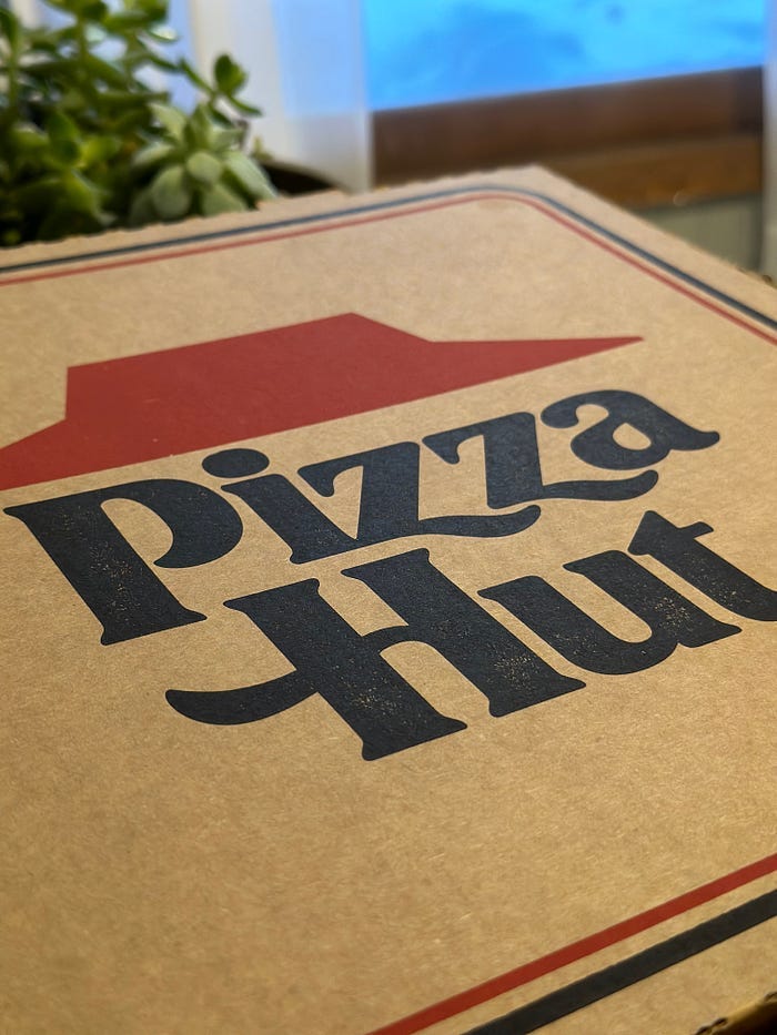 A cardboard box with a Pizza Hut label.
