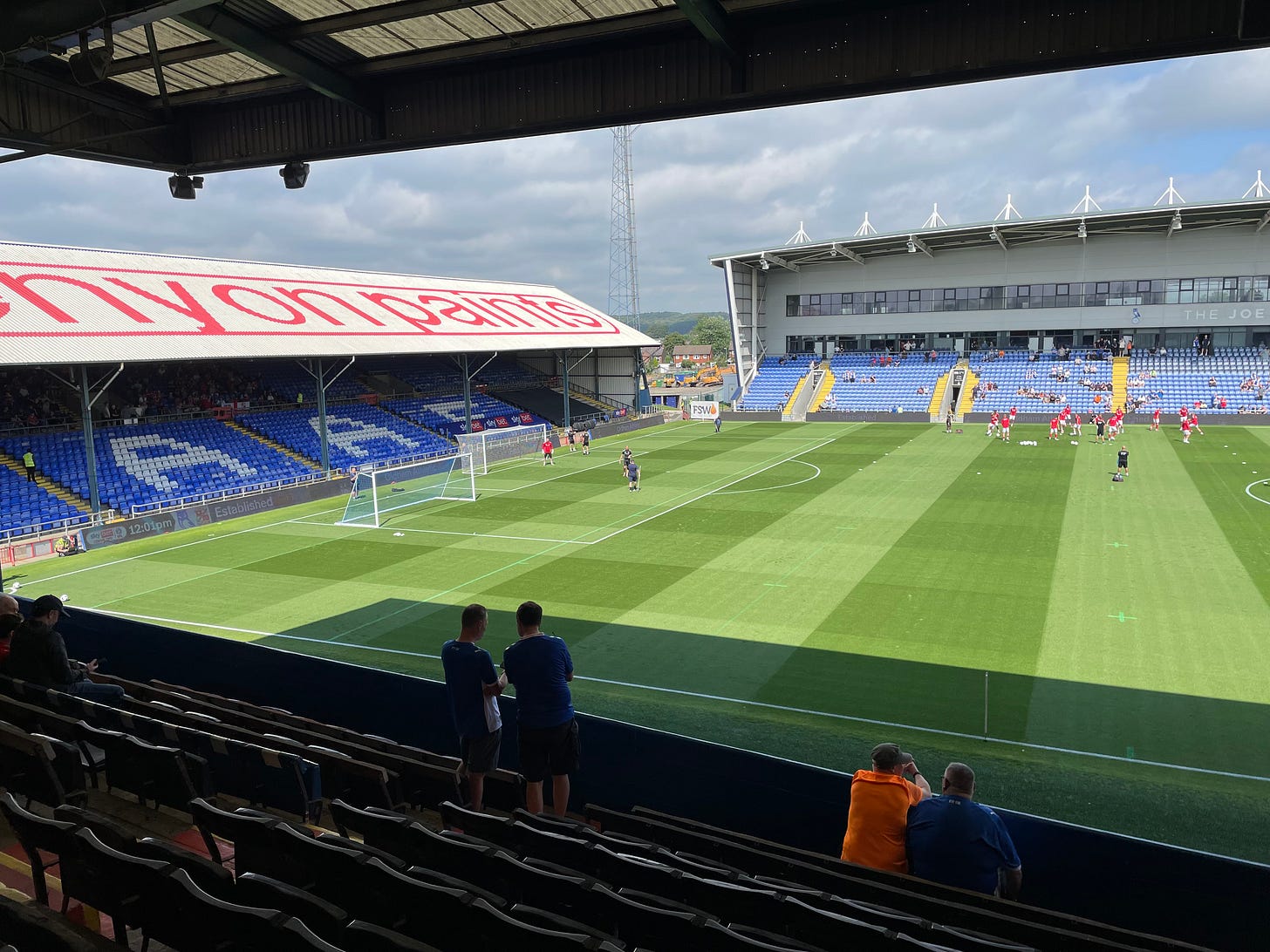 The pitch at Oldham in the sunshine, the stands almost empty as the match doesn't start for another hour. The teams are warming up.