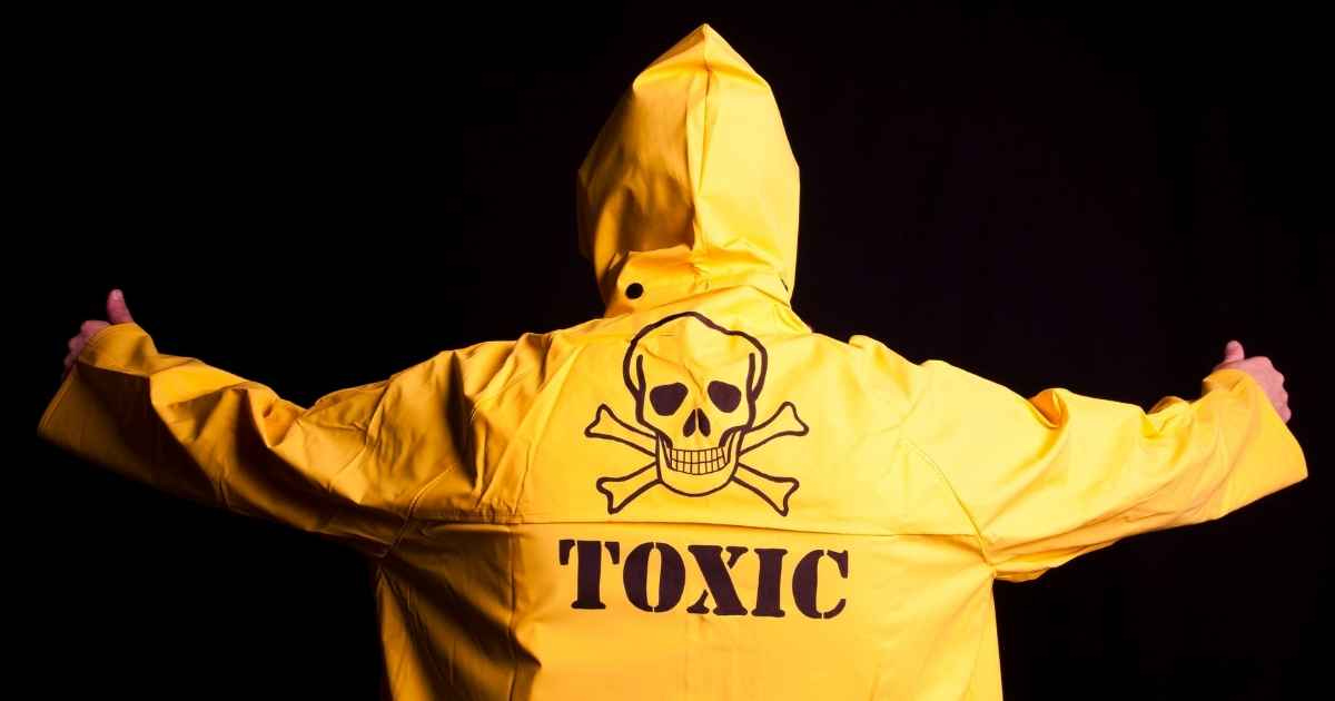 man standing with his back facing towards you with the words toxic written on the back of his coat