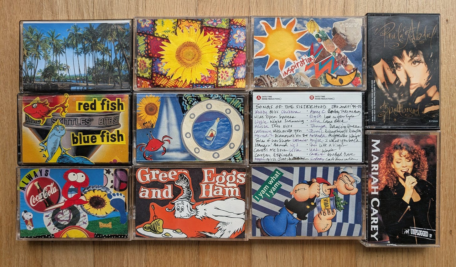 Eleven cassette tapes are laid out in a grid. Five of them have magazine collages. One has songs and the names of who added it. The two cassettes on the end are Paula Abdul and Mariah Carey.