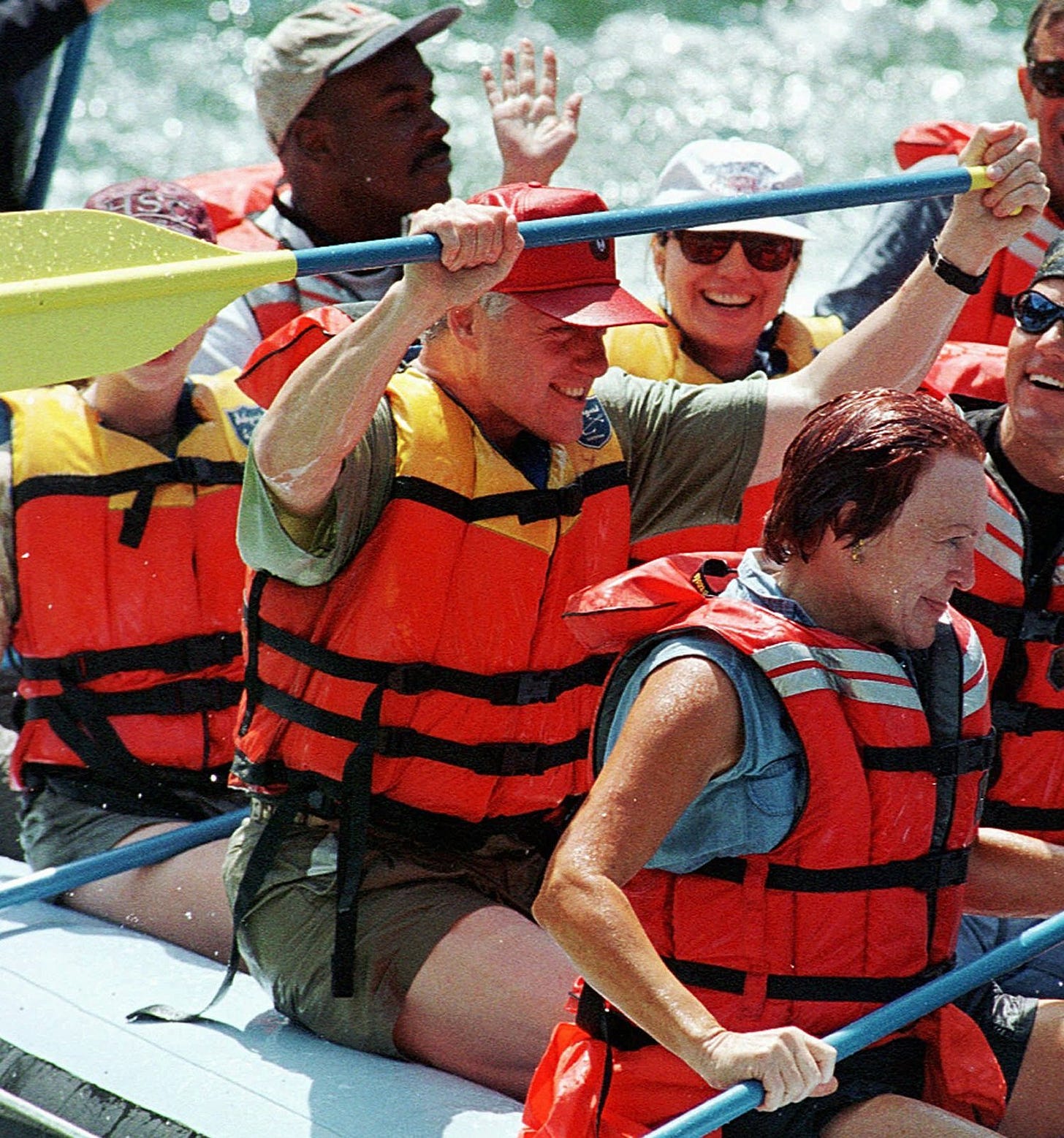 President Bill Clinton waves his paddle and Hillary Clinton waves after navigating the Big Kahuna Rapids during a raft trip on the Snake River near Alpine Junction, Wyoming, August 17, 1996. President Bill Clinton waves his paddle and Hillary Clinton waves after navigating the Big Kahuna Rapids during a raft trip on the Snake River near Alpine Junction, Wyoming, August 17, 1996.