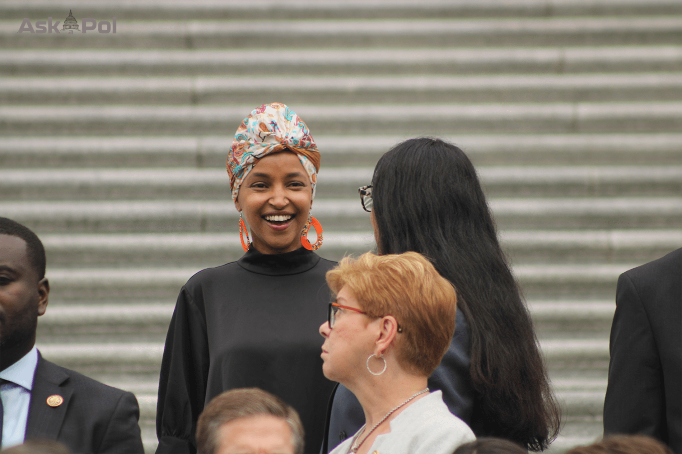A female Muslim US Congresswoman laughs with another female lawmaker on the Capitol's steps. Photo: Logan Johnson for © www.askapolpolitics.com 