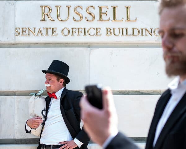 A man in a top hat, red bowtie and jacket with a fake mustache. 
