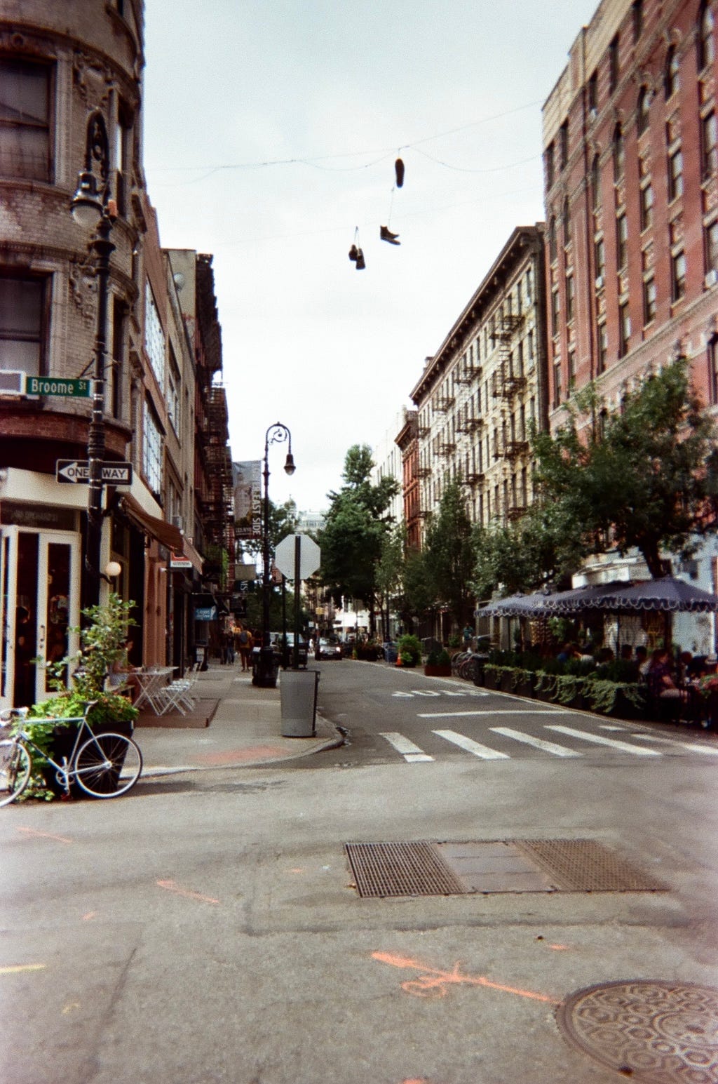 NYC street photography shoes on a wire broome street