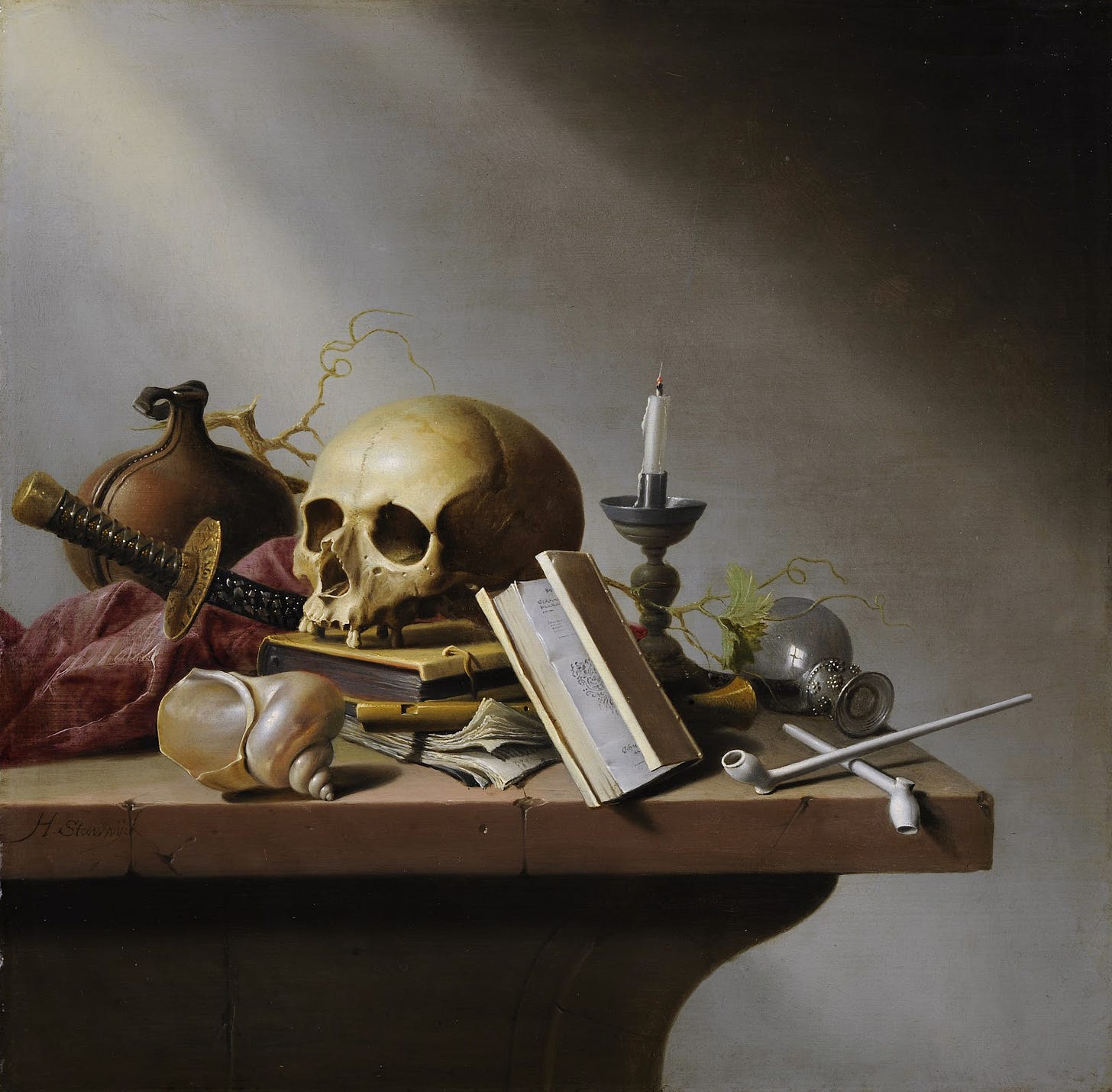Skull, sword, shells and a snuffed lamp arranged on a table