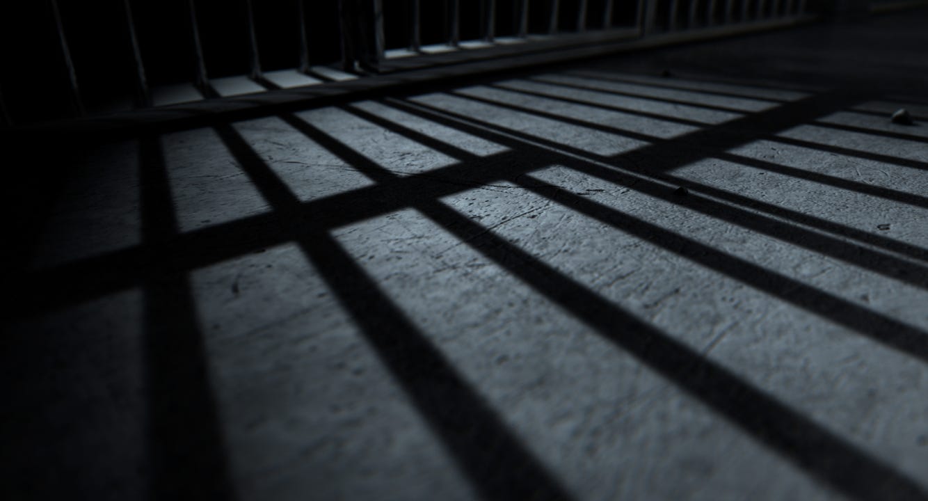 Long, ominous shadow of the prison cage on the floor