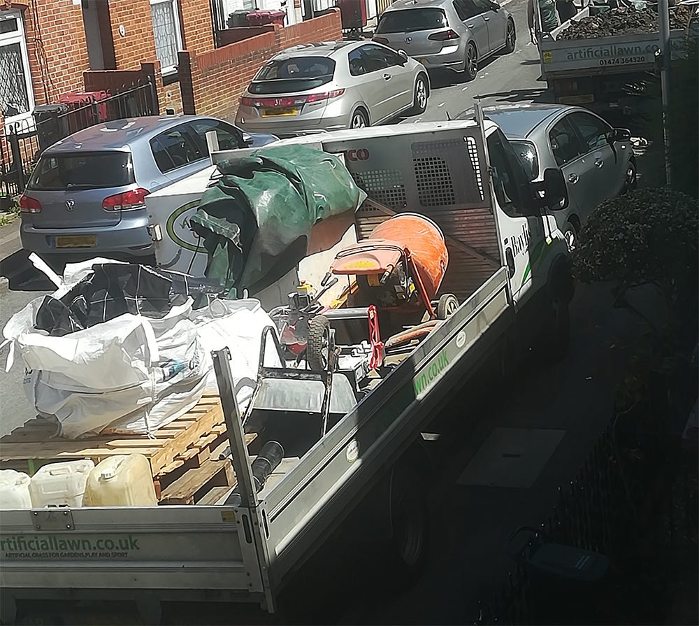 Two trucks parked and full of industrial construction materials. Belonging to the Artificial Lawn Company.