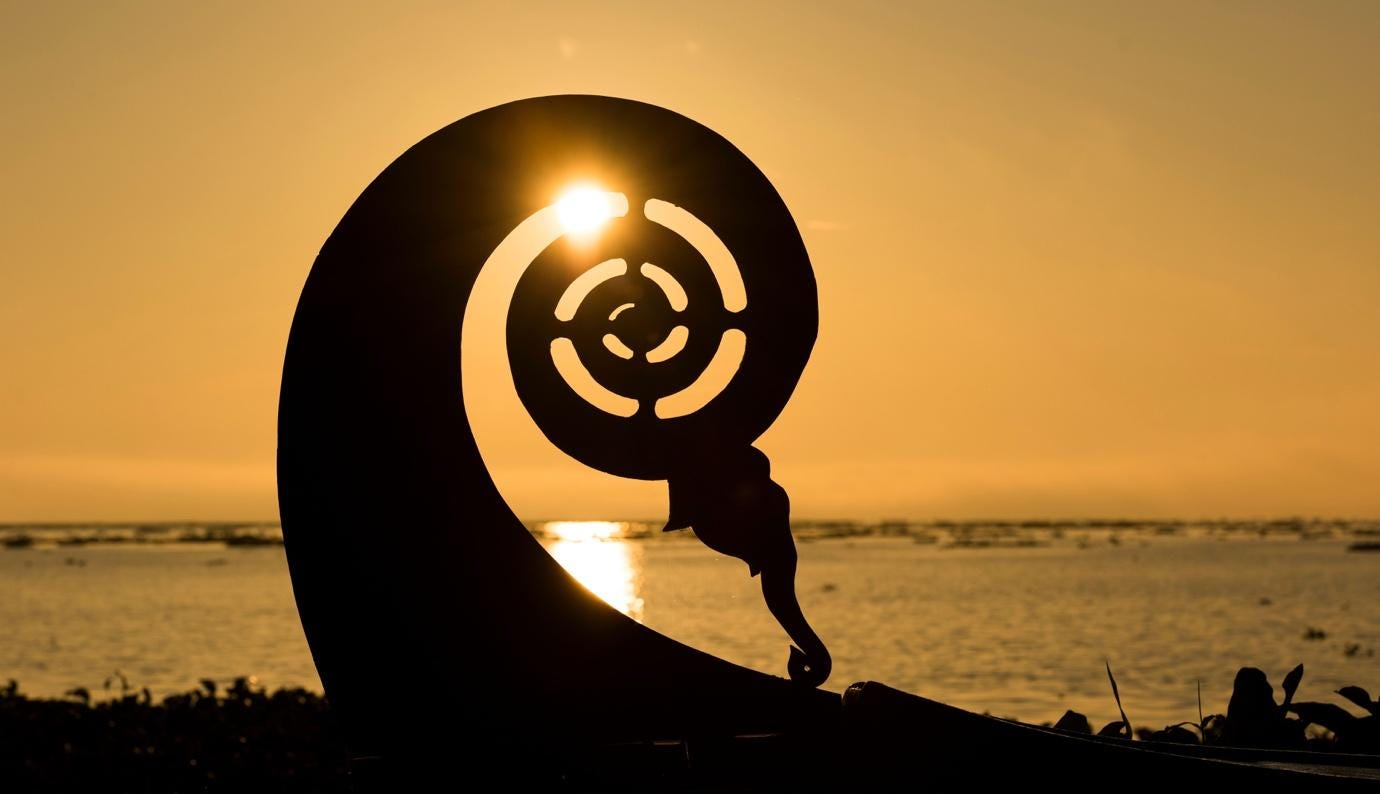 A silhouette of a sculpture on a beach

Description automatically generated