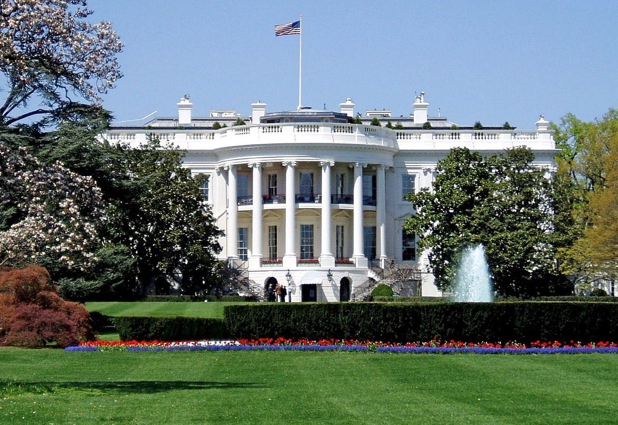 The south facade of the White House on a sunny day with flowers blooming.
