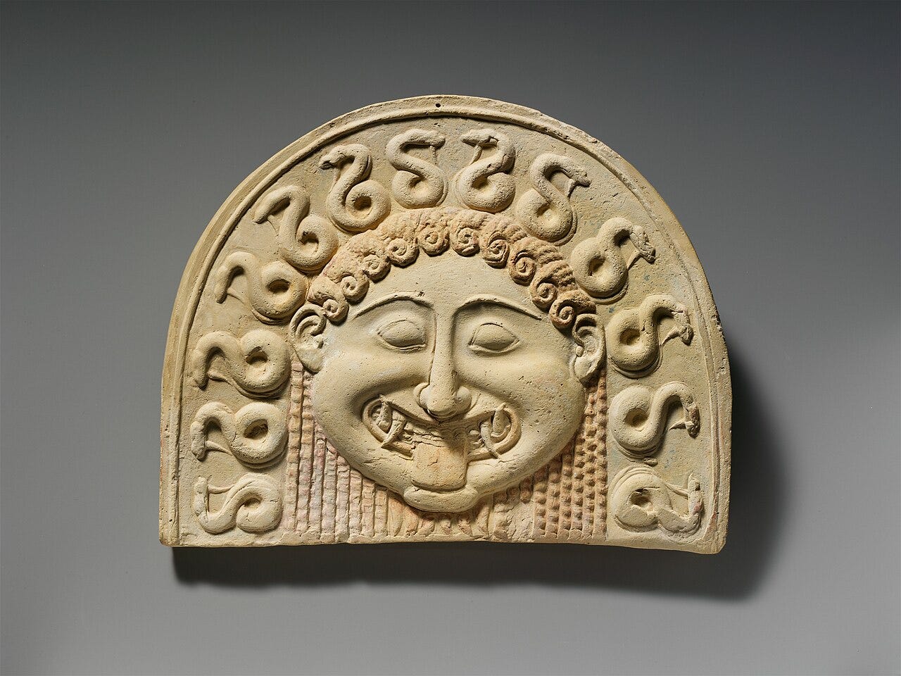 Archaic Greek clay Gorgon face on a roof tile Archaic Greek clay Gorgon face on a roof tile
