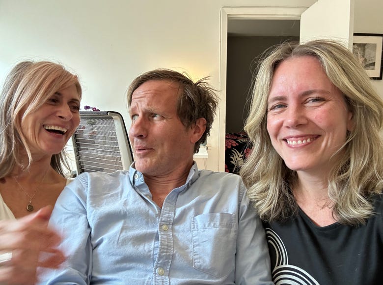 A group of people sitting together smiling

Description automatically generated