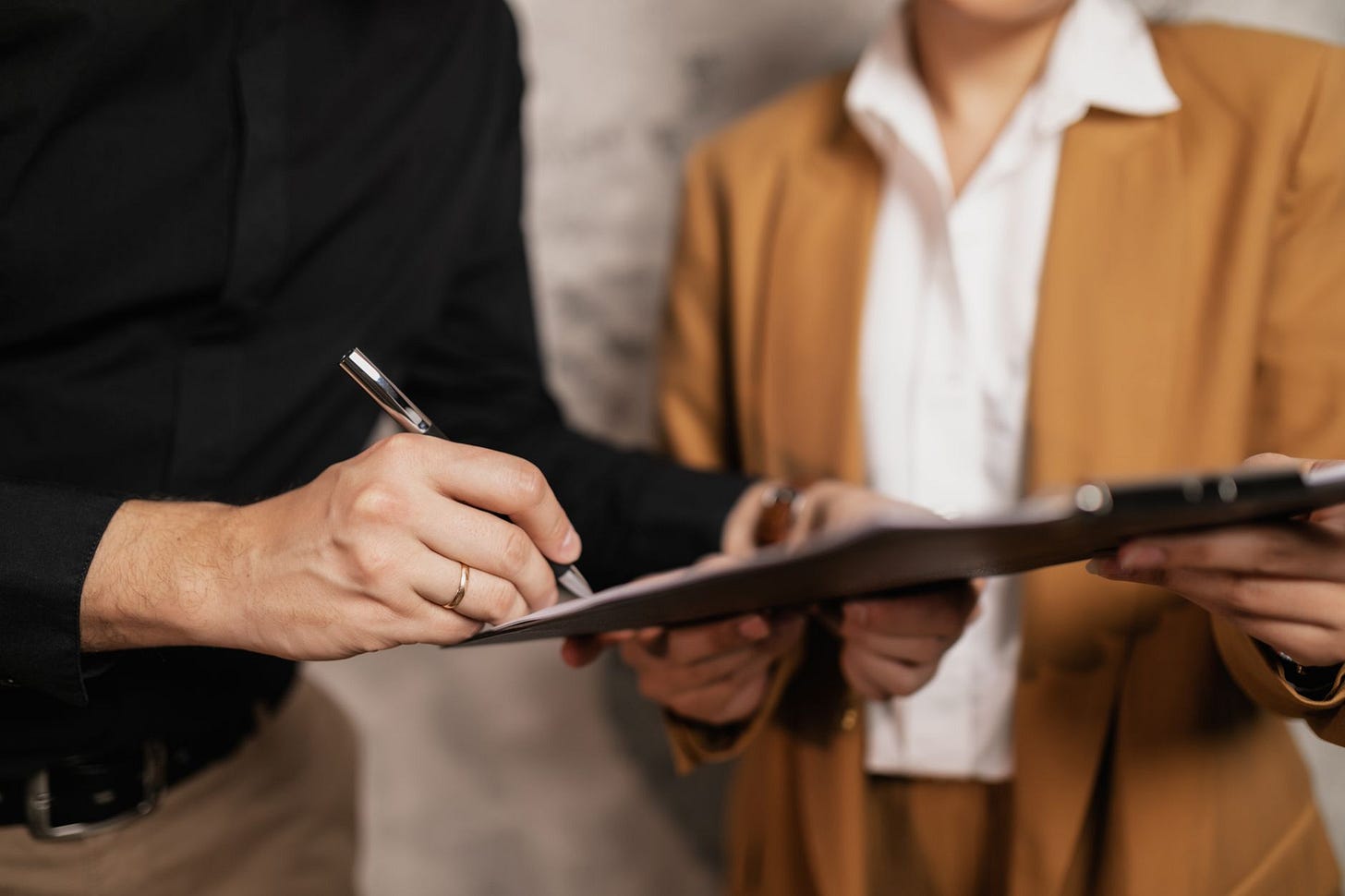 Photo by Alena Darmel on Pexels Close-up of two professionals signing a document indoors, focus on hands and pen. (stock photo)
