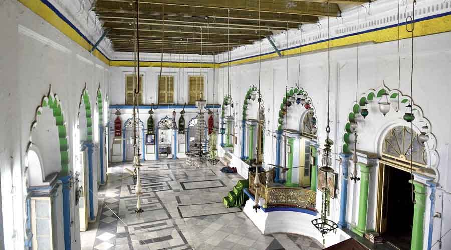 A picture of a wide wall with multiple arched windows, coloured white with green and yellow accents.